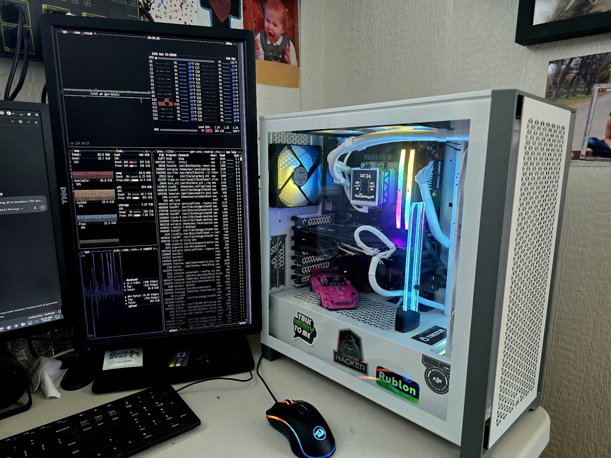 White desktop PC with liquid cooling, illuminated memory, and a system-monitoring display alongside it